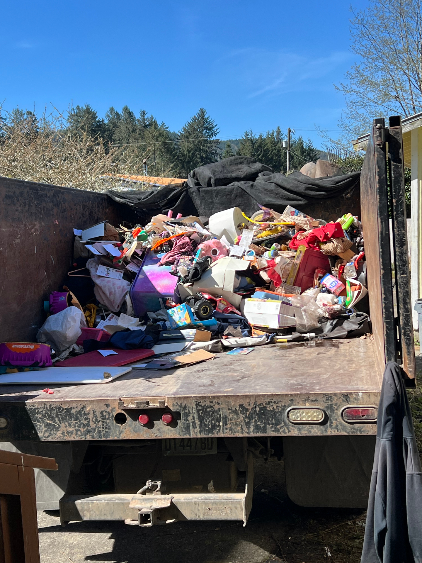 Dump truck fully loaded with household junk and toys from a full property cleanout