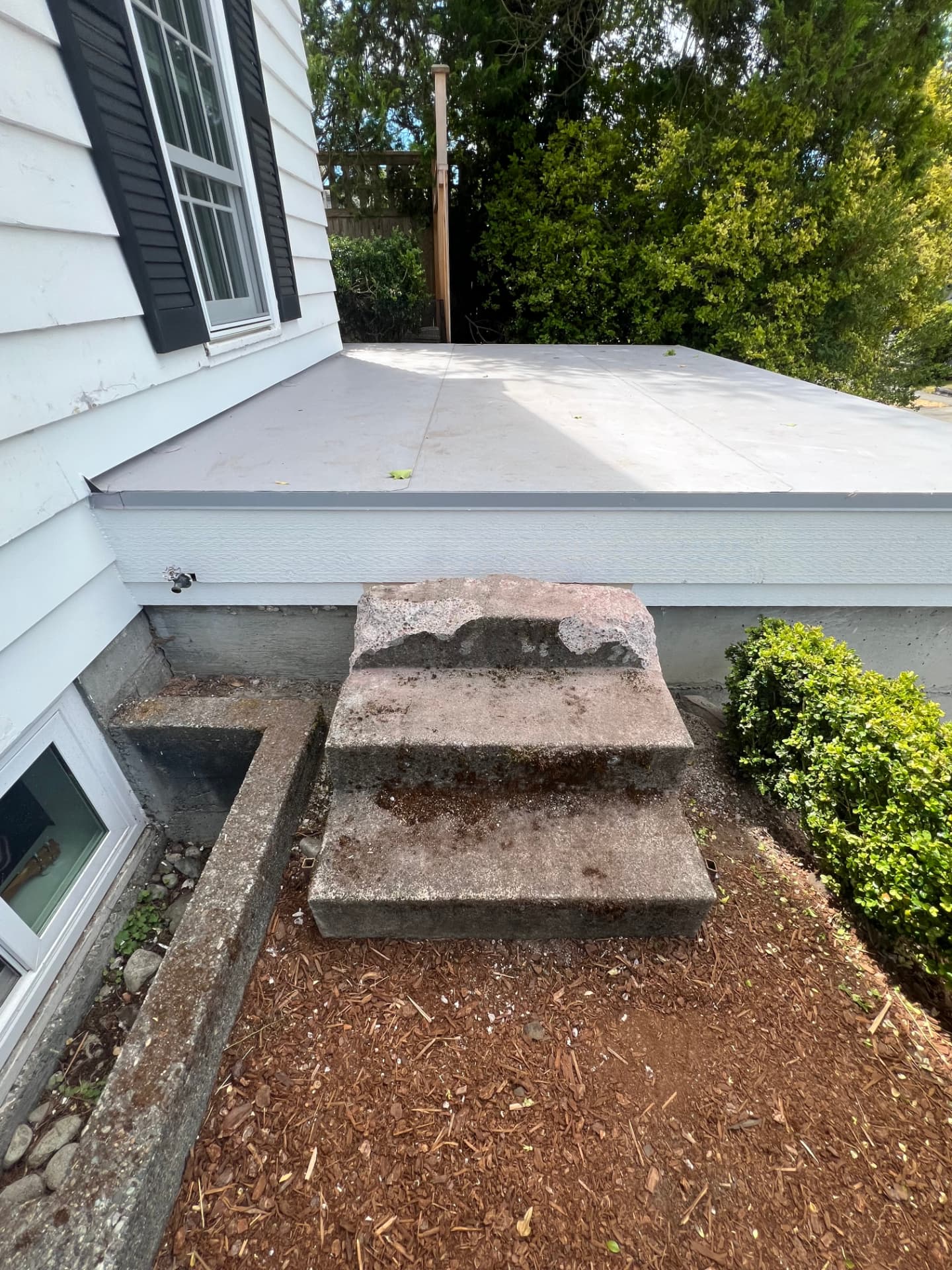 Old concrete stairs against the side of a home before demolition