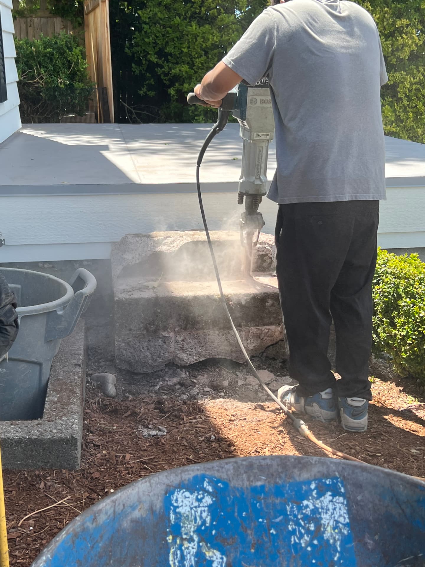 Crew breaking up concrete stairs with a jackhammer during demo