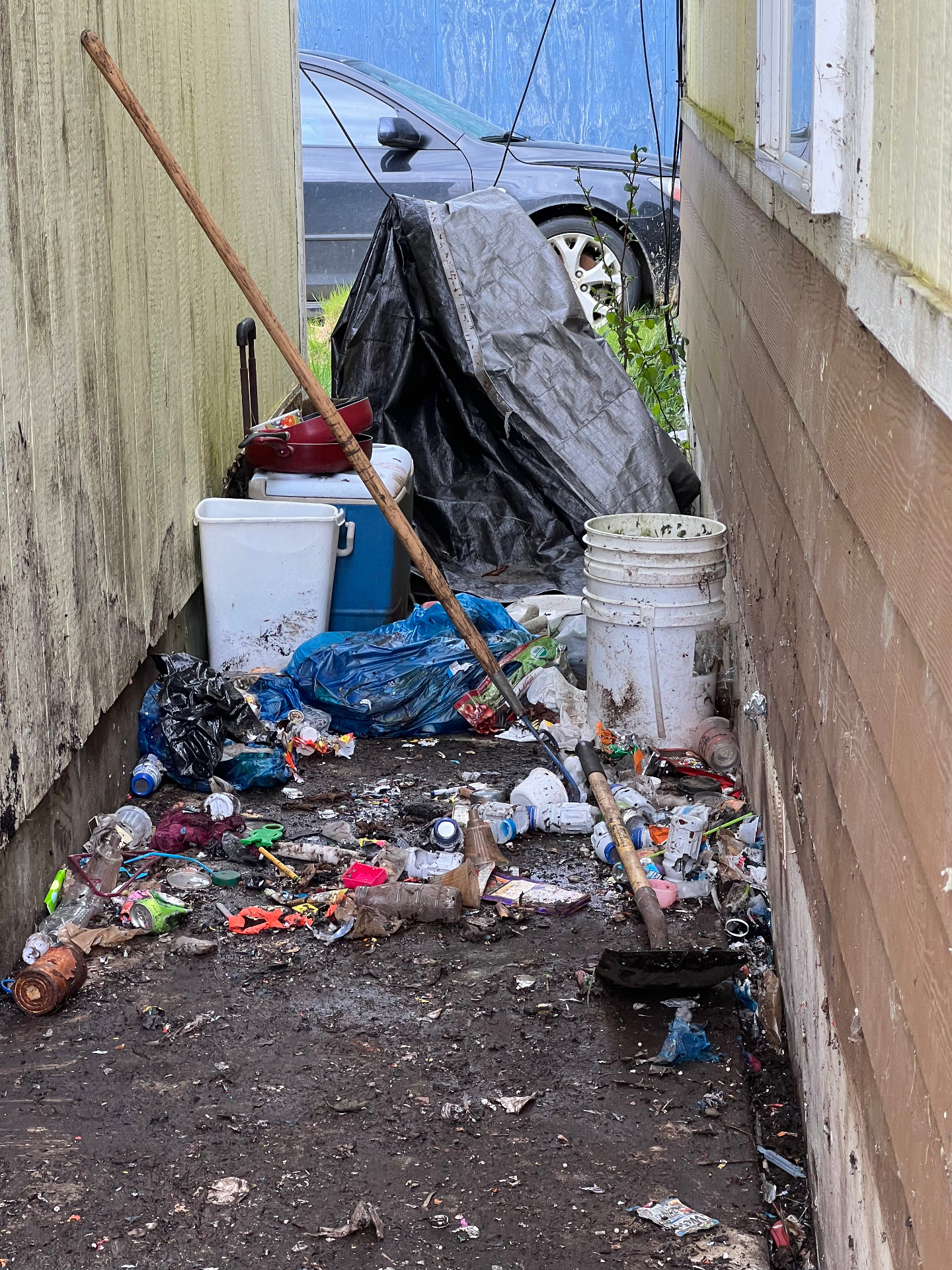 Side yard packed with trash and cleanup debris before haul away